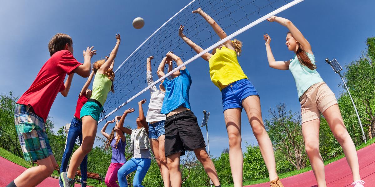 Teenager spielen im Freien Volleyball