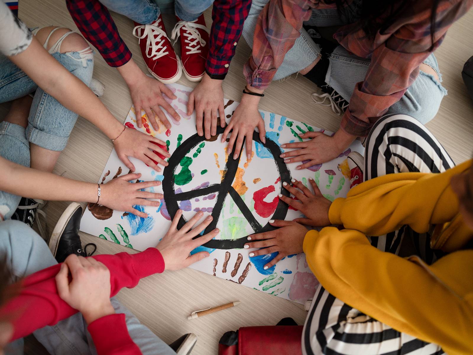 Kinderhände auf einem Poster mit gemaltem Friedenszeichen