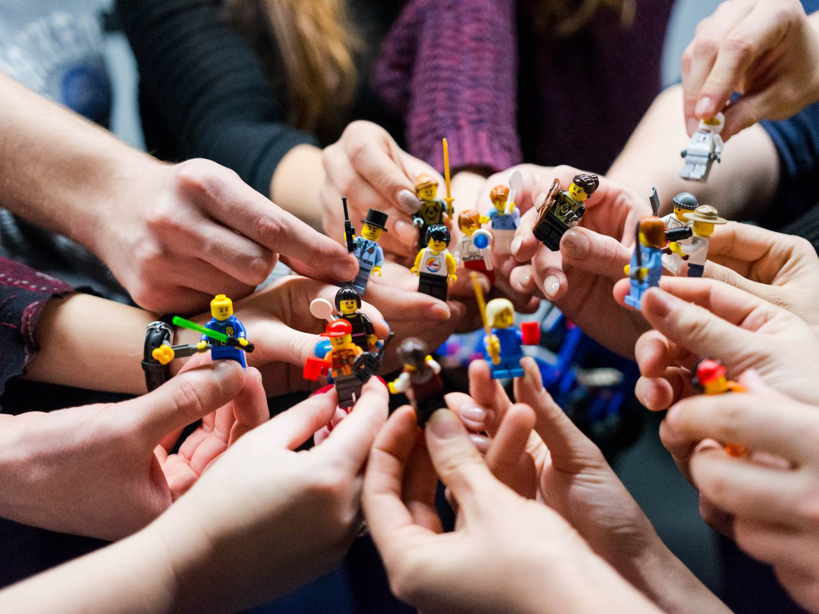 Hände halten Playmobilfiguren, die miteinander "kämpfen"