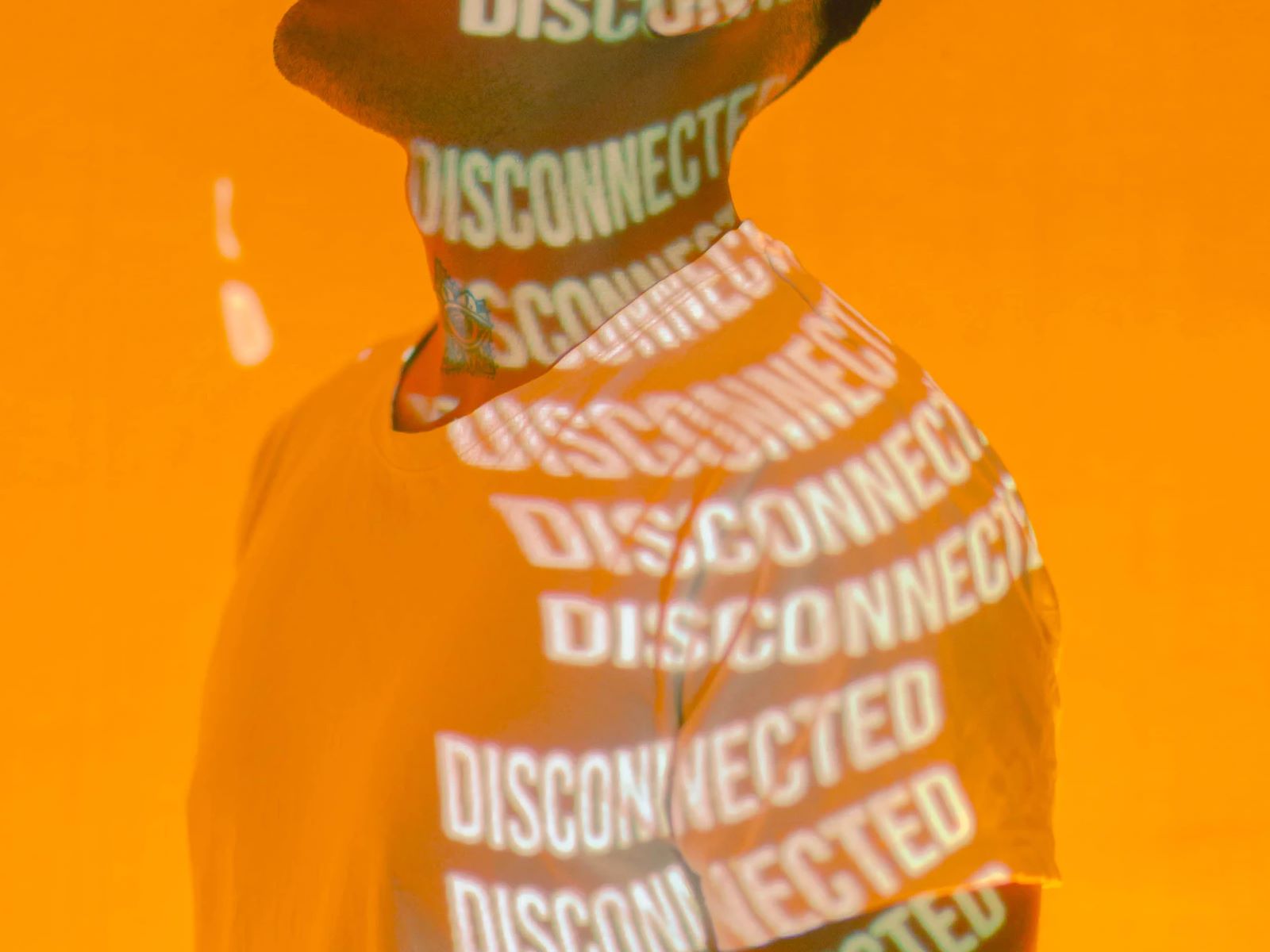 Mensch vor oranger Wand mit Schriftzug Disconnected