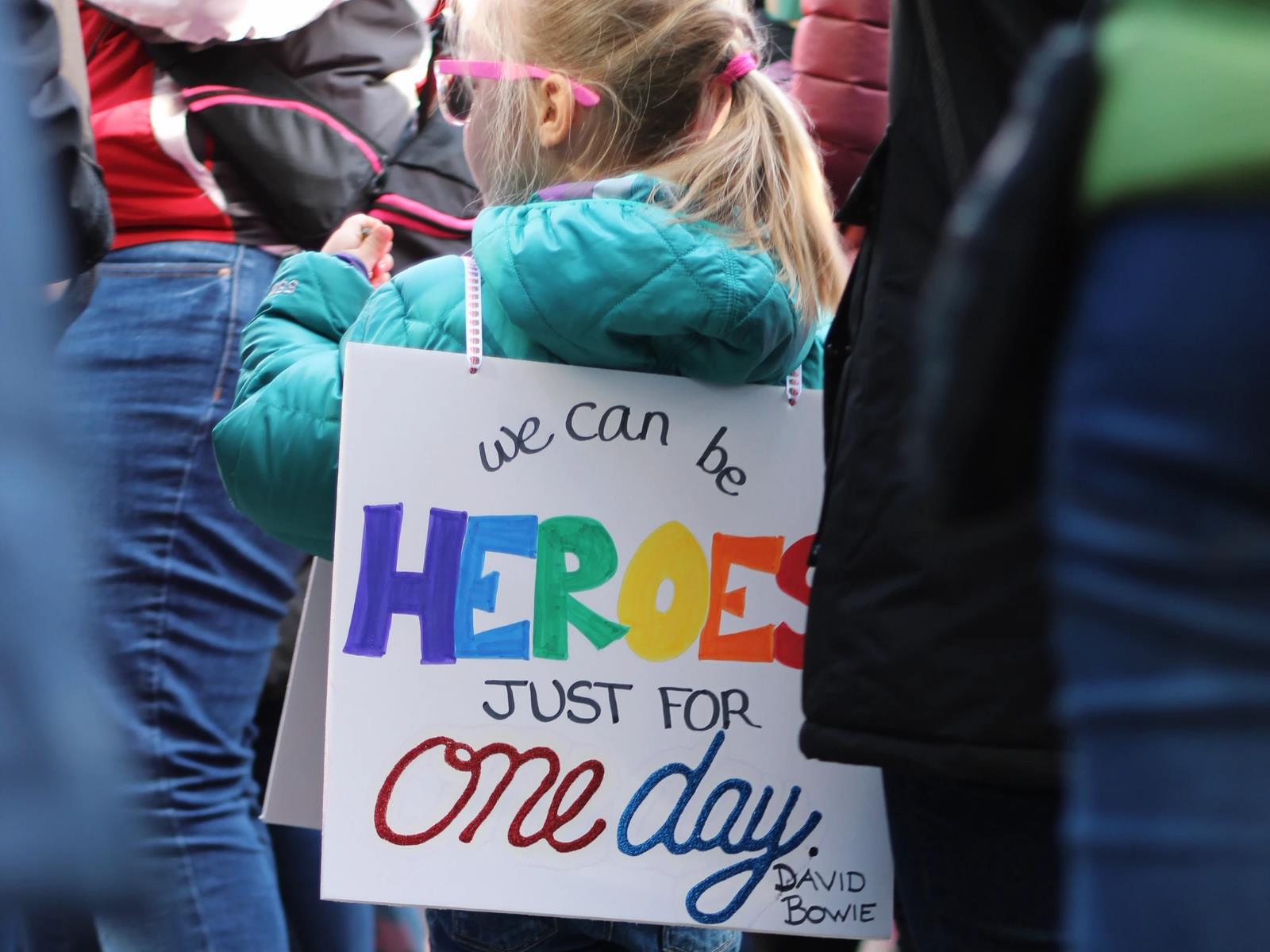 Mädchen mit Sandwich-Schild "We can be Heros"