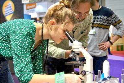 Eine Jugendliche schaut in ein Mikroskop