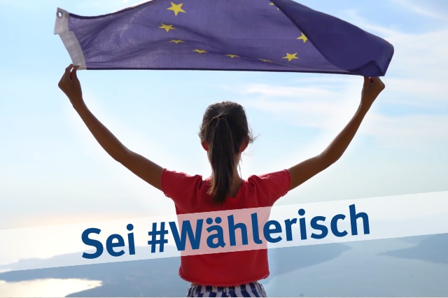 Junge Frau lässt auf einem Hügel mit Blick auf Meer und Hügel eine EU-Flagge wehen.